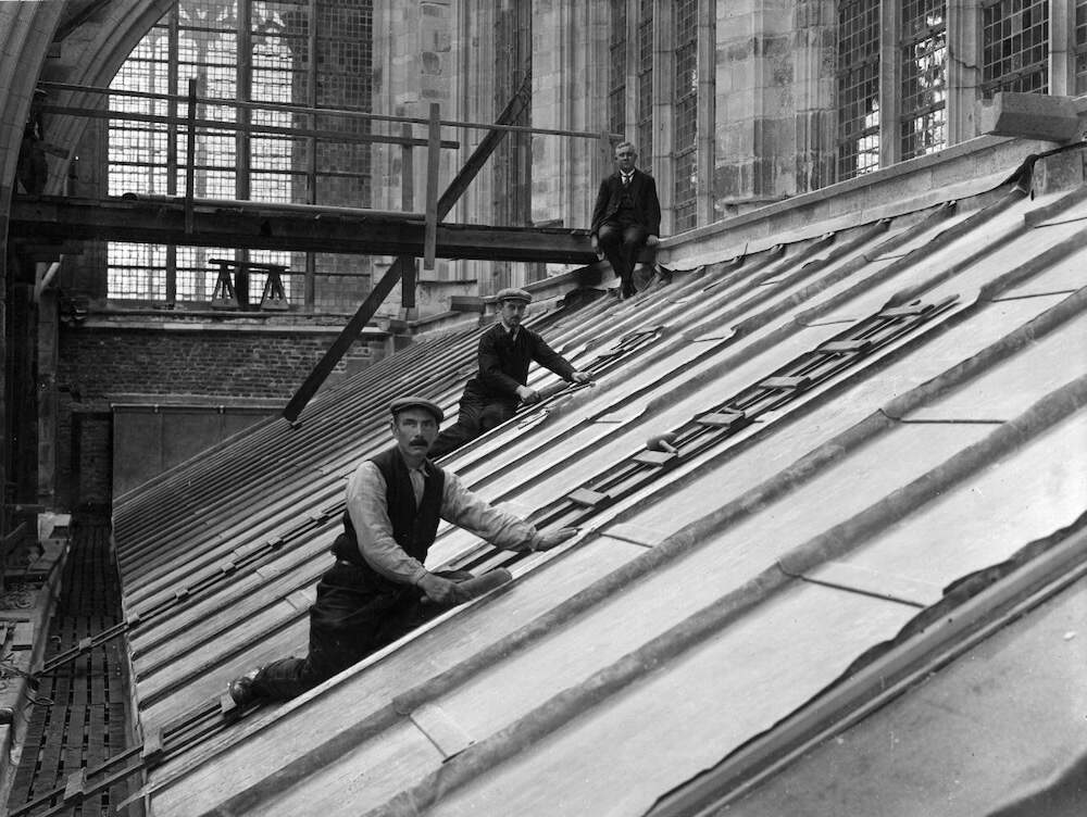 Kap van de kooromgang tijdens de restauratie van de zuidgevel van de Domkerk met enkele loodgieters die lood kloppen