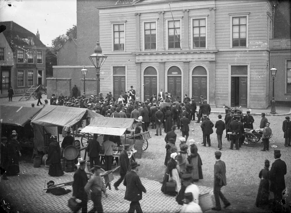 Marktkramen en verkopers voor de Stadsschouwburg te Utrecht De marktverkopers zijn vermoedelijk Jacob Hollander kiezen en mond en Marcus Hollander likdoorns 1895