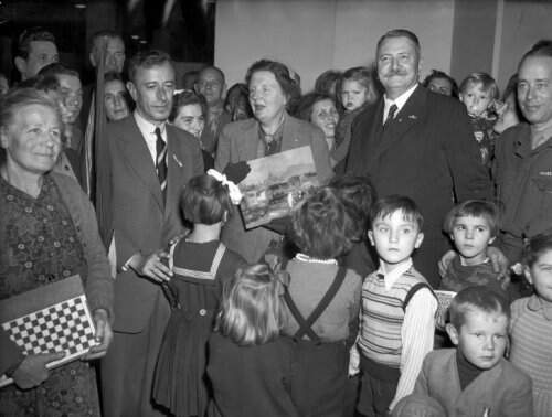 Koningin Juliana temidden van enkele Hongaarse vluchtelingen in het Jaarbeursgebouw in Utrecht hier ontvangt zij een schilderij De Donau in Budapest 19 november 1956