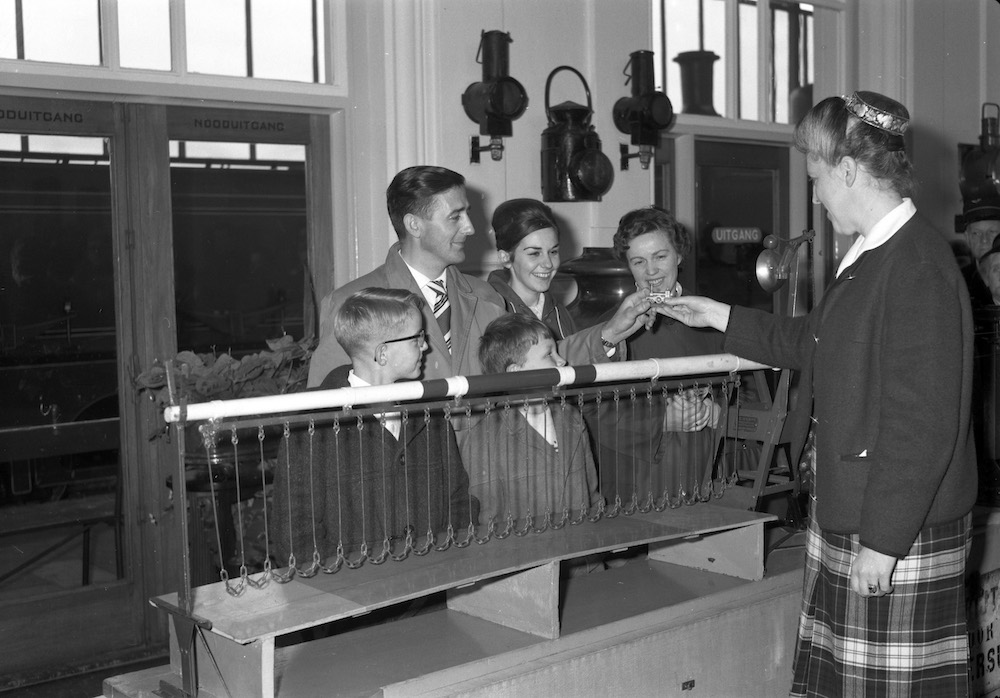mej MA Asselberghs conservatrice van het Spoorwegmuseum te Utrecht die de heer de Kruijff en zijn familie uit Hilversum ontvangt als 100000ste bezoekers in 1963