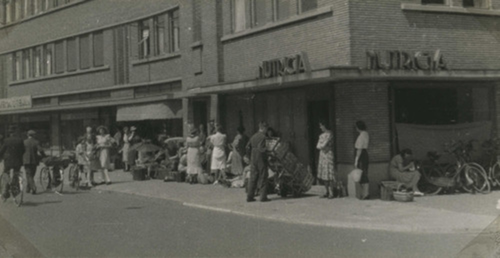 1942 Zomer 1942. Nederland leert in de rij staan. Bij Nutricia voor een flesch yoghurt