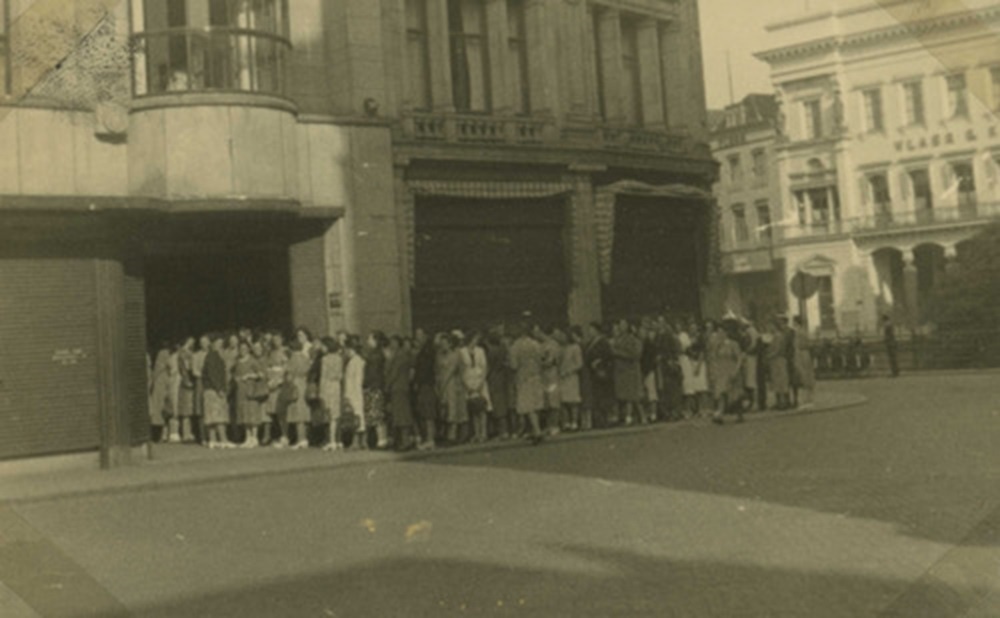 1942 Zomer 1942. Nederland leert in de rij staan. Bij Vroom en Dreesman s morgens om 8 uur voor een paar kousen
