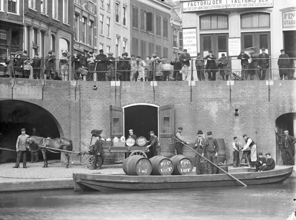 Het overladen van wijnvaten van wijnhandel Finj Co in opslagkelder onder het huis Keyserrijk 1906